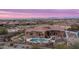 Drone shot of backyard featuring a pristine pool, spa, outdoor seating, and landscape under a twilight sky at 8612 S 30 Th Way, Phoenix, AZ 85042