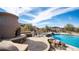 Outdoor area with desert landscaping, gorgeous pool and integrated waterfall spa and stacked stone fireplace at 8612 S 30 Th Way, Phoenix, AZ 85042