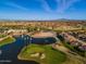 Panoramic aerial view of a golf course with a serene lake, lush fairways, and well-maintained landscaping, capturing the community's beauty at 9638 E Tranquility Way, Sun Lakes, AZ 85248