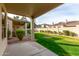 Backyard featuring a covered patio, lush green grass, and a perimeter privacy fence at 9638 E Tranquility Way, Sun Lakes, AZ 85248