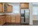 Kitchen with stainless steel refrigerator and matching appliances, complemented by warm wood cabinetry and dark wood flooring at 1170 S Agnes Ln, Gilbert, AZ 85296