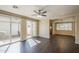 Open-concept living room with sliding glass doors, dark wood floors, and seamless transition to the dining and kitchen areas at 1170 S Agnes Ln, Gilbert, AZ 85296