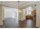 Open living space with a view of the kitchen, featuring stainless steel appliances and dark wood flooring throughout at 1170 S Agnes Ln, Gilbert, AZ 85296