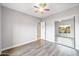 Neutral bedroom featuring wood-look floors, a ceiling fan, and a mirrored closet at 13018 S 177Th Ln, Goodyear, AZ 85338