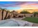 Inviting backyard featuring a hot tub, outdoor fireplace, and beautifully landscaped surroundings at 1307 E Desert Broom Way, Phoenix, AZ 85048