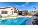 Sparkling swimming pool with lush landscaping, patio area, and covered pergola at 14717 W Ventura St, Surprise, AZ 85379