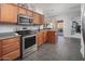 Kitchen with wooden cabinetry, stainless steel appliances, and access to outdoor area at 16038 W Acapulco Ln, Surprise, AZ 85379