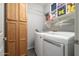Laundry room features cabinetry, shelving, and modern appliances at 16038 W Acapulco Ln, Surprise, AZ 85379