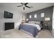 Bedroom with a ceiling fan, TV, and attached bathroom at 16038 W Acapulco Ln, Surprise, AZ 85379