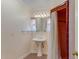 Bathroom featuring a pedestal sink, mirror with decorative lighting, and a shower with a red tiled surround at 1631 Palmcroft Se Dr, Phoenix, AZ 85007