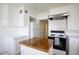 Well-lit kitchen with white cabinets, island with wood countertop, and modern appliances at 1631 Palmcroft Se Dr, Phoenix, AZ 85007