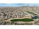Scenic aerial view of Estrella community with desert golf course, a pond, houses, and mountains in the distance at 18143 W Buckhorn Dr, Goodyear, AZ 85338