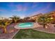 Lush backyard showcasing a pool, mature palm trees, and vibrant desert landscaping, ideal for enjoying outdoor living at 18143 W Buckhorn Dr, Goodyear, AZ 85338