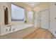 Bright bathroom featuring a tub, shower, and large window for natural light at 18143 W Buckhorn Dr, Goodyear, AZ 85338