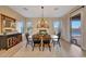 Elegant dining area with a fireplace, wood flooring, and ample natural light at 18143 W Buckhorn Dr, Goodyear, AZ 85338