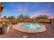 Inviting backyard pool with stone accents, desert landscaping, and lush palm trees creates a serene outdoor oasis at 18143 W Buckhorn Dr, Goodyear, AZ 85338
