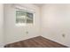 A cozy bedroom with wood laminate flooring and bright natural light from the window at 19601 N 99Th Dr, Sun City, AZ 85373