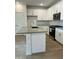 Bright kitchen with a grey countertop island, white cabinets, subway tile backsplash, and stainless appliances at 2079 N Marketside Ave, Buckeye, AZ 85396