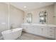 Modern bathroom featuring dual sinks, a soaking tub, white cabinets, and elegant fixtures at 24201 N 87Th St, Scottsdale, AZ 85255