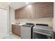 Clean laundry room featuring sleek cabinets, modern washer and dryer, and a stainless steel sink at 24201 N 87Th St, Scottsdale, AZ 85255