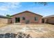 A view of the backyard features a block fence surrounding the property, a sliding glass door and an AC unit at 25073 W Dove Trl, Buckeye, AZ 85326