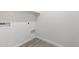 Functional laundry room area with hookups, shelving, and neutral tile flooring at 25073 W Dove Trl, Buckeye, AZ 85326