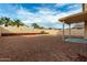 Backyard featuring rock landscaping, a covered patio, and mature trees at 25724 W St James Ave, Buckeye, AZ 85326