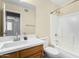 Well-lit bathroom featuring single sink, wood vanity, and tub with shower at 25724 W St James Ave, Buckeye, AZ 85326