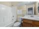 Bathroom featuring a tub with white tile surround and a single-sink vanity with wood cabinets at 25724 W St James Ave, Buckeye, AZ 85326