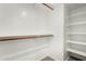 Walk-in closet with wood rods and white shelving provides ample storage space at 25724 W St James Ave, Buckeye, AZ 85326