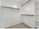 Walk-in closet with wooden racks and white shelves provides ample storage space at 25724 W St James Ave, Buckeye, AZ 85326