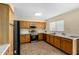 Open kitchen with stainless steel appliances, wood cabinets, and ample countertop space at 25724 W St James Ave, Buckeye, AZ 85326