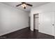 Cozy bedroom featuring dark floors, ceiling fan, and a closet with sliding doors at 290 N Nash Way, Chandler, AZ 85225