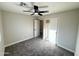 Neutral bedroom with a ceiling fan, plush carpeting, closet with sliding doors, and a doorway to another room at 3345 E Edgewood Ave, Mesa, AZ 85204