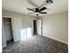 Bright bedroom boasts a ceiling fan, sliding closet doors, gray carpeting, and doorway to additional space at 3345 E Edgewood Ave, Mesa, AZ 85204