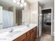 A spacious bathroom with a double vanity, large mirror, and combined shower and tub at 41655 W Somerset Dr, Maricopa, AZ 85138