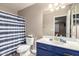 Updated bathroom with stylish vanity, fixtures, toilet, and tiled shower behind a decorative curtain at 41655 W Somerset Dr, Maricopa, AZ 85138