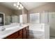 Bright bathroom with double vanity, bathtub, and a shower for a spa-like experience at home at 41655 W Somerset Dr, Maricopa, AZ 85138