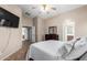 Comfortable bedroom features neutral tones, a ceiling fan, a TV, and an adjoined bathroom for convenience at 41655 W Somerset Dr, Maricopa, AZ 85138