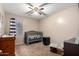 Cute Bedroom with crib, dresser, carpet, ceiling fan, and a window offering comfort for your little one at 41655 W Somerset Dr, Maricopa, AZ 85138