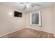 Cozy bedroom featuring a ceiling fan, window, neutral tones, and plush carpeting for added comfort at 41655 W Somerset Dr, Maricopa, AZ 85138