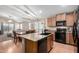 Open concept kitchen with wood cabinets, modern black appliances, and an island at 41655 W Somerset Dr, Maricopa, AZ 85138