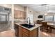 Kitchen island with granite countertops, black faucet, and view to living room at 41655 W Somerset Dr, Maricopa, AZ 85138