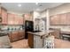 Kitchen island with granite countertops, wood cabinets, black appliances at 41655 W Somerset Dr, Maricopa, AZ 85138