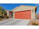 Single-story home with desert landscaping, a red garage door, and a long concrete driveway at 4402 W Bush Bean Way, San Tan Valley, AZ 85144