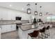 Modern kitchen featuring white cabinets, granite counters, an island with bar seating, and stylish pendant lights at 4402 W Bush Bean Way, San Tan Valley, AZ 85144