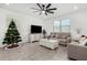 Bright living room featuring neutral furniture, tile floors, a ceiling fan, and large windows at 4402 W Bush Bean Way, San Tan Valley, AZ 85144