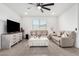 Bright living room featuring neutral furniture, tile floors, a ceiling fan, and large windows at 4402 W Bush Bean Way, San Tan Valley, AZ 85144