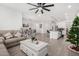 Open-concept living space featuring neutral furniture, tile floors, a ceiling fan, and an adjacent dining area at 4402 W Bush Bean Way, San Tan Valley, AZ 85144