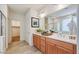 Spacious bathroom with dual sinks, wooden cabinets, and a large mirror, providing ample storage and light at 4609 S 122Nd S Dr, Avondale, AZ 85323